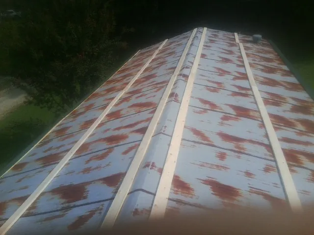 Rusted metal roof panels with new wood purlins before replacement — Storm Damage Roof Repair in Bear Creek by Roofing Brothers